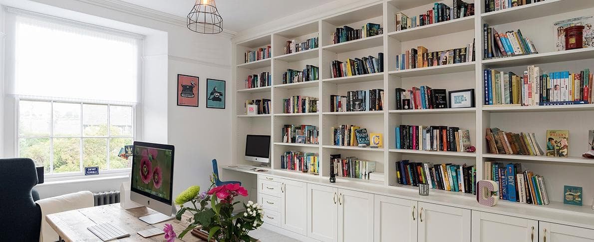 White fitted full wall storage unit with home office desk